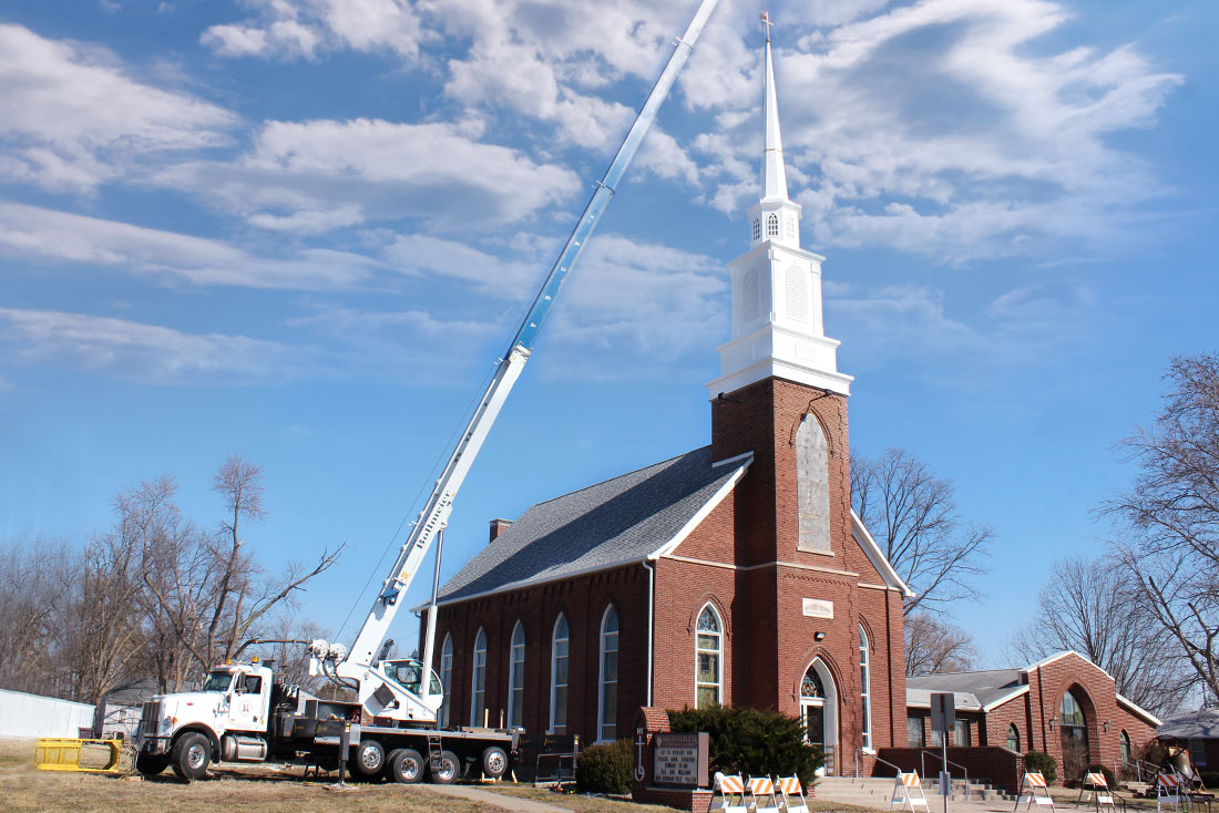 Crane placing cross on the steeple